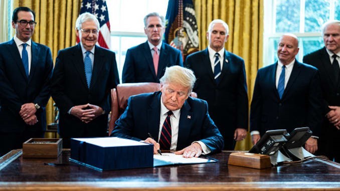 President Donald Trump ondertekent het 2000-miljard-wetsvoorstel ‘H.R. 748, the CARES Act’ in de Oval Office van het Witte Huis op 27 maart 2020. Bron: Erin Schaff | Getty Images